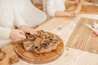 Children's hands carve cookies on gingerbread dough from figurines. girl preparing christmas cookies