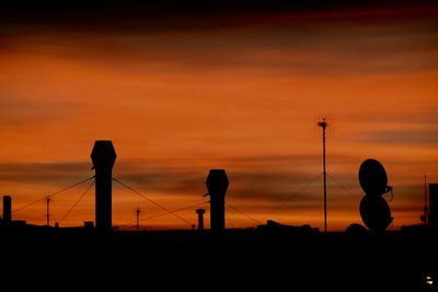 Silhouette people photographing tower against sky during sunset