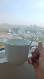 Cropped hand holding coffee cup