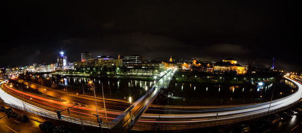 High angle view of light trails on bridge by river at night