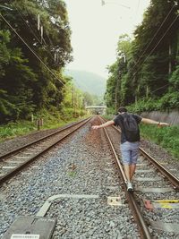 Rear view of man on railroad track
