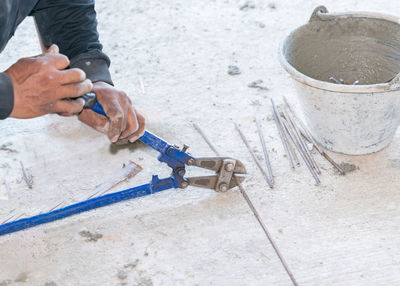 Big cutting pliers cut steel wire rod in construction site.