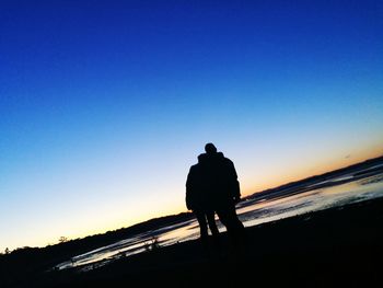 Rear view of silhouette man against clear sky