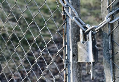 Close-up of padlock on chainlink fence