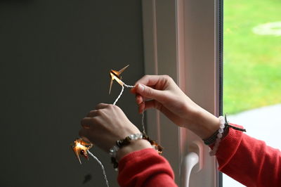 Cropped hand of woman holding sparkler