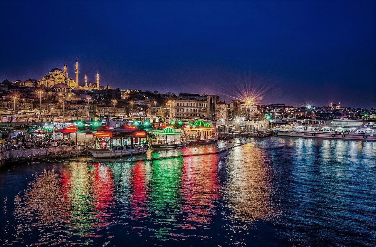 night, city, illuminated, building exterior, reflection, built structure, architecture, multi colored, cityscape, transportation, sky, river, outdoors, water, city life, bridge - man made structure, nautical vessel, urban skyline, no people, skyscraper