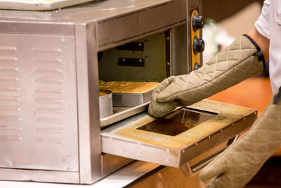 Midsection of man working in kitchen