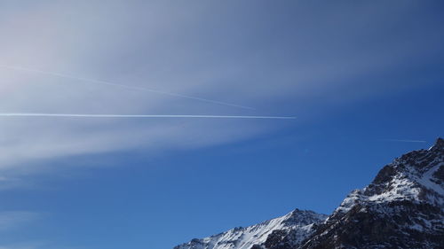 Low angle view of vapor trail against blue sky