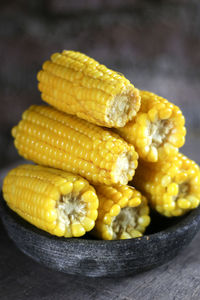 Close-up of stacked corns in container on table