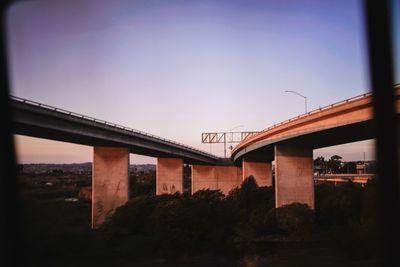 Low angle view of bridge against sky at dusk