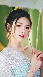 Portrait of smiling young woman with arms crossed standing outdoors