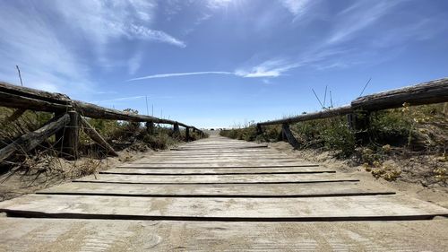 Surface level of boardwalk against sky