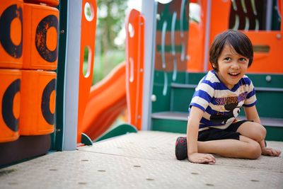 Portrait of smiling boy sitting outdoors