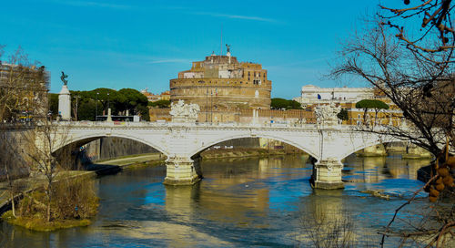 Arch bridge over river against sky