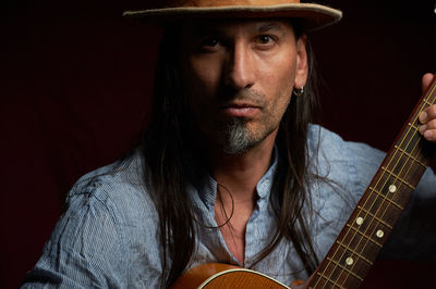 Long-haired gyiatrist wearing a hat looking straight into the camera