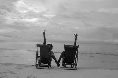 Lounge chairs on beach against sky