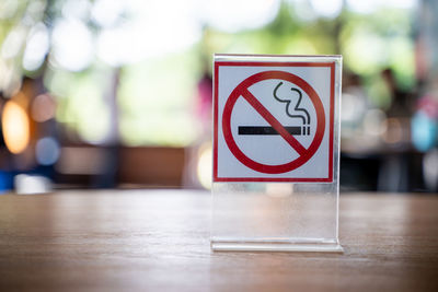 Close-up of no smoking sign on table