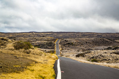 Road passing through landscape against sky