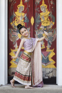 Portrait of girl standing against wall