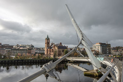 View of bridge over river against cloudy sky