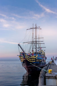 Sailboat moored in sea against sky