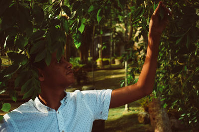 Young man holding leaves in park