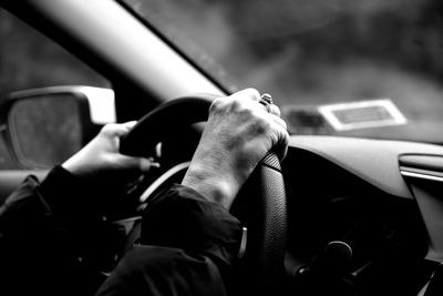 Cropped hands of woman driving car