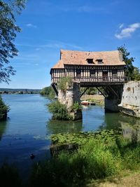 Building by lake against sky