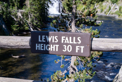 Close-up of information sign against trees