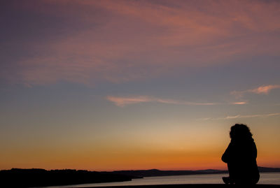 Silhouette woman standing against sky during sunset