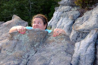 Shocked woman behind rock