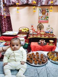 Cropped hand of woman holding cute boy in temple at home