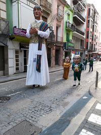 People standing on footpath by street in city