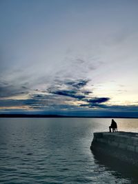 Silhouette of person in sea against sky