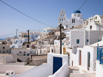 Buildings in city against clear blue sky