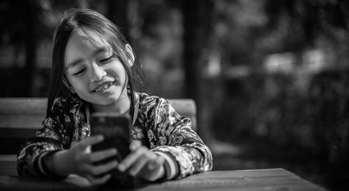 Close-up of girl using mobile phone outdoors