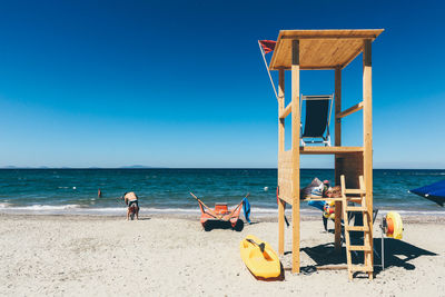 Deck chairs on beach against sky