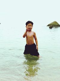Portrait of happy boy standing in water