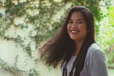 Portrait of smiling young woman standing outdoors