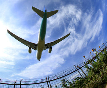 Low angle view of airplane flying against sky