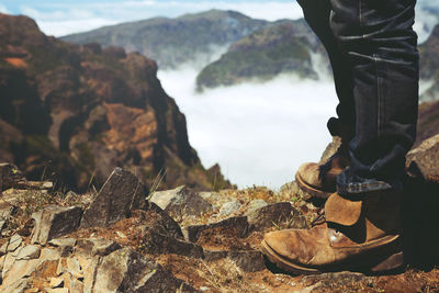 Low section of man standing on rock