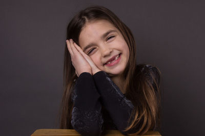 Portrait of smiling girl against gray background