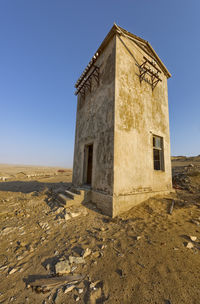 Old building on field against clear sky