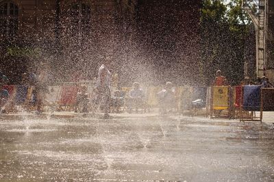 Water splashing from fountain at park with people in background