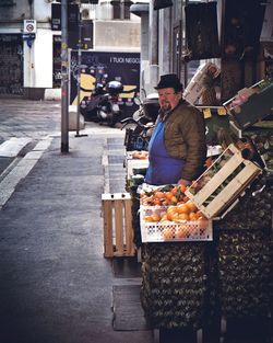 Man standing at market stall in city