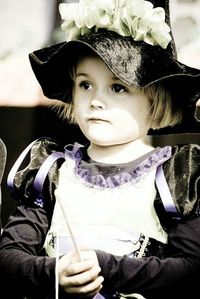 Portrait of cute girl sitting on wall