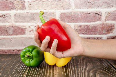 Cropped image of hand holding red bell peppers