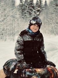 Portrait of smiling young woman standing on snow covered field