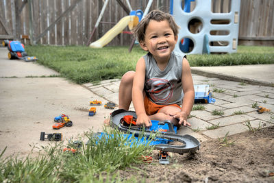 Portrait of cute boy sitting at toy car