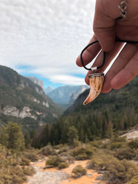 Midsection of man against mountain range against sky